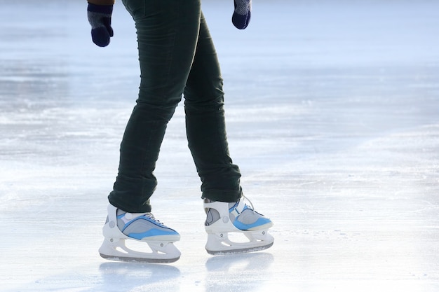 The legs of a man skating on the ice rink