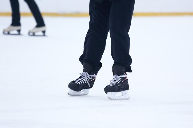 The legs of a man skating on an ice rink