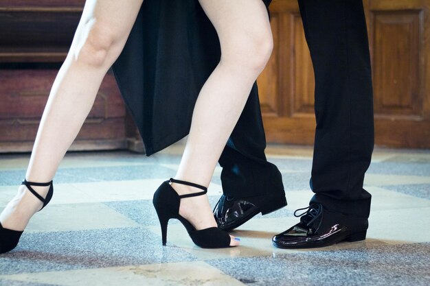 Legs of man and woman dancing argentine tango black shoes