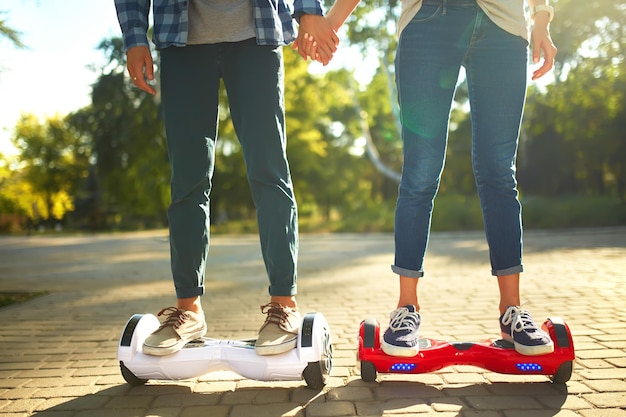 Legs of man and woman riding on the Hoverboard together outdoor Active lifestyle technology future