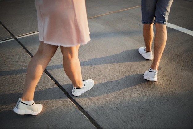 Gambe di un uomo e di una donna al tramonto