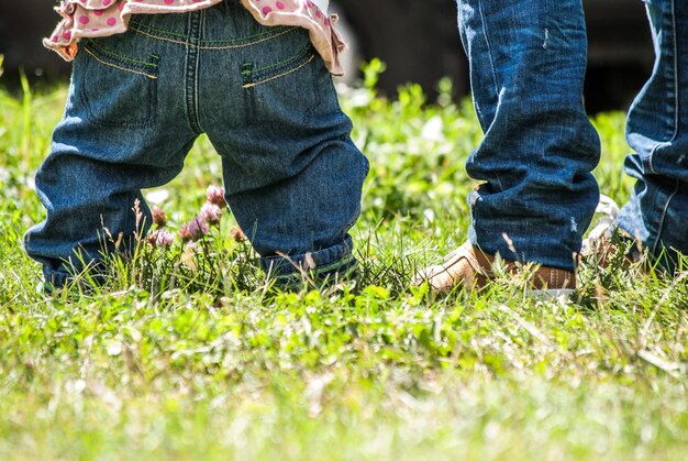 ジーンズのクローズアップで母と子の足