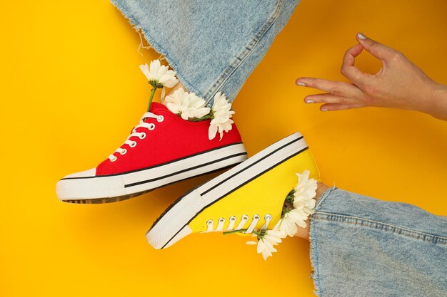 Legs in multicolored sneakers on a yellow background