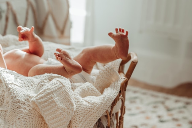 The legs of a newborn baby in the cozy warm lighting of the house