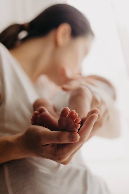 Legs of a newborn baby in parental hands