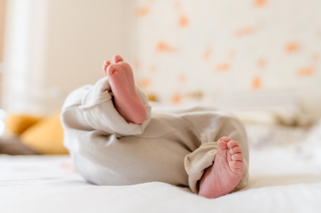 The legs of a newborn baby on a white blanket