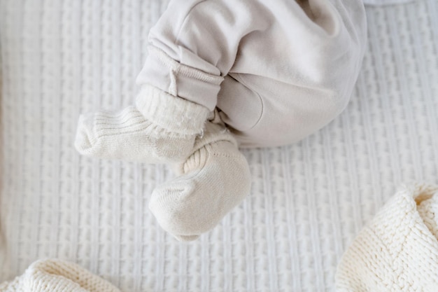 The legs of a newborn baby on a white blanket
