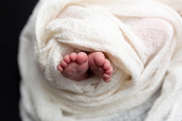 흰 담요에 신생아의 다리. 새로 태어난 아기. 작은 아기 발