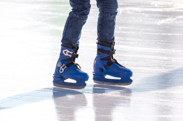 Gambe di un pattinatore sul pattinaggio sul ghiaccio sulla pista di pattinaggio su strada. sport invernali. hobby e ricreazione attiva nello sport.