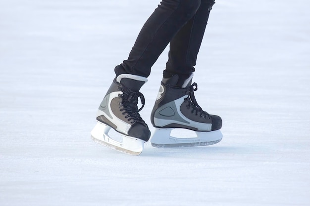 아이스 링크에서 스케이트 남자의 다리입니다. 취미와 스포츠. 휴가 및 겨울 활동.