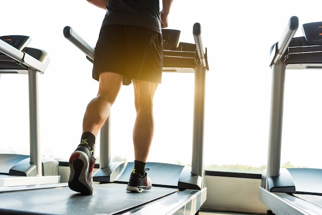 Legs of sportsman running on treadmill in fitness gym center. Sport and Healthy lifestyle concept.