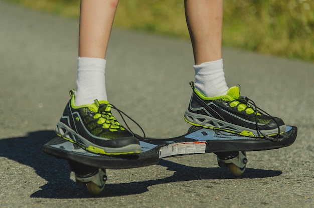 Photo legs of a teenage child on a waveboard riding in the park