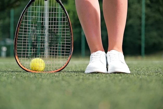 Legs and tennis racket closeup ball and racket on the tennis court