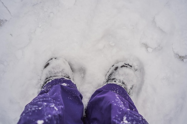 深い雪の屋外旅行と発見の概念に立っている旅行者の足