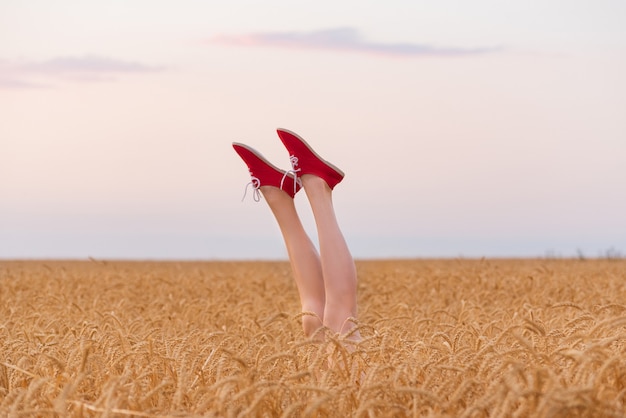 Legs upwards against the sky and fields of ripe wheat.