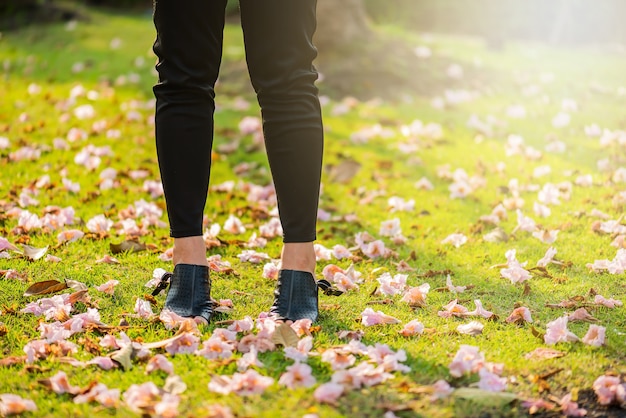 Foto punto di vista di gambe di una donna con i fiori. gambe asiatiche della donna