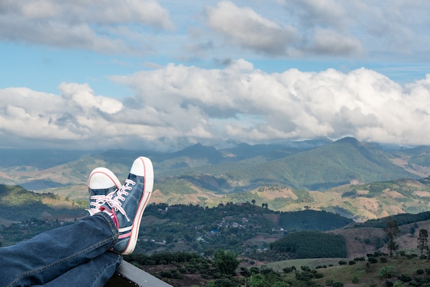 Photo legs of woman raised up high on beautiful natural mountains background