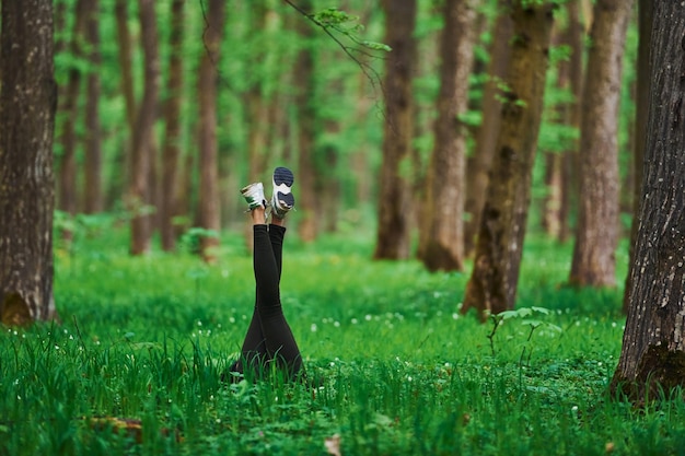 Legs of woman that have a rest and lying down on ground in forest