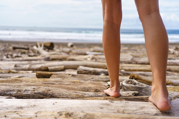 해변을 걷는 여자의 다리. 코스타리카의 자코 비치