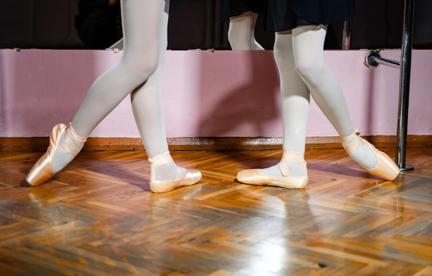 Foto gambe di giovani ballerine provare nella classe di danza vestito con collant bianchi e scarpe da ballo concetto di scarpe da punta