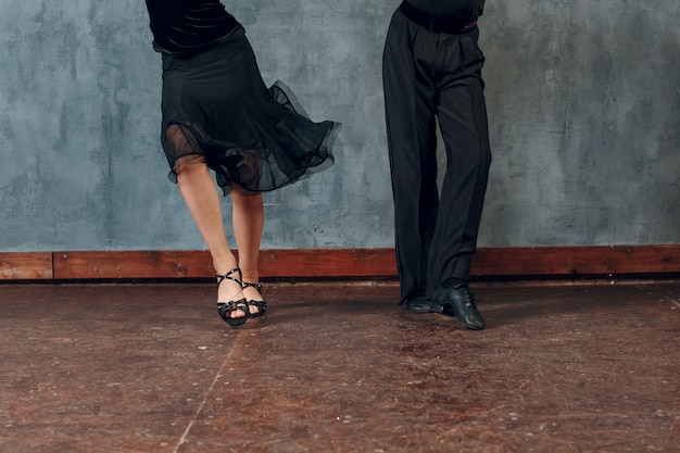 Photo legs of young couple boy and girl dancing in ballroom dance jive.