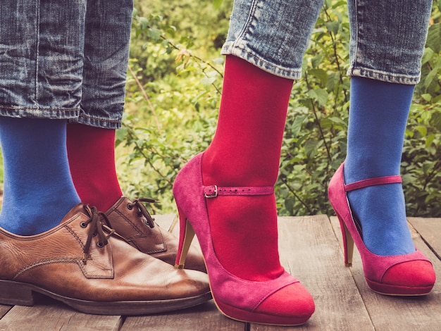 Legs of a young couple in stylish shoes and colorful socks