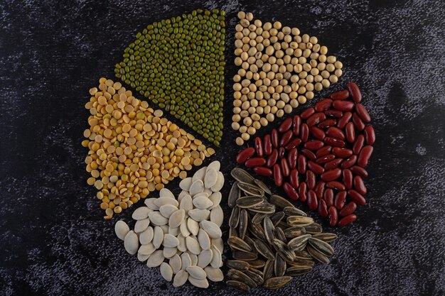 Legumes arranged in a circle on the black cement floor