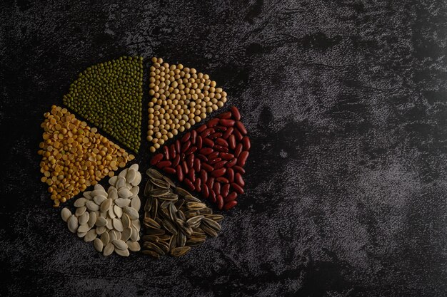 Legumes arranged in a circle on the black cement floor