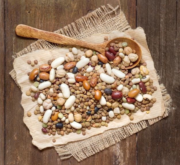 Legumes mix with a spoon on a wooden table close up