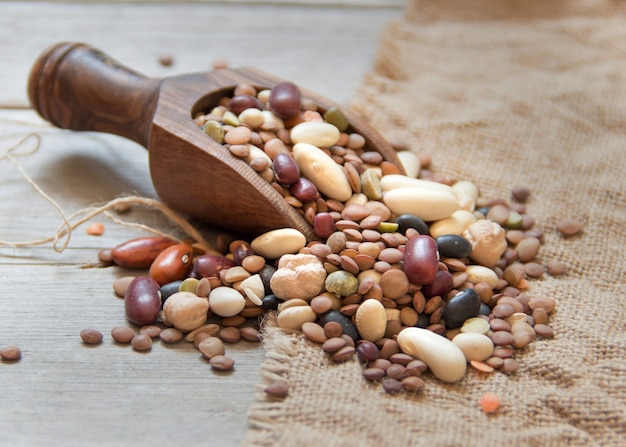 Legumes mix in the wood scoop close up on a wooden table