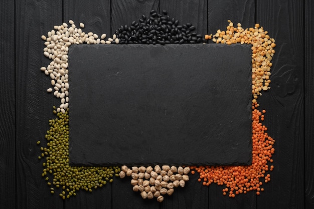 Photo legumes overhead flat lay shot on a dark rustic wooden background with a place for text