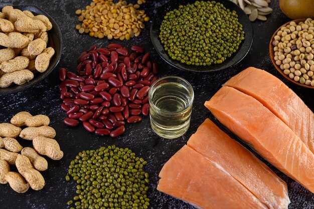 Photo legumes and salmon placed on a black cement floor