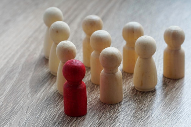 Foto leiderschapsconcept rode houten poppen voor anderen in driehoekvorm