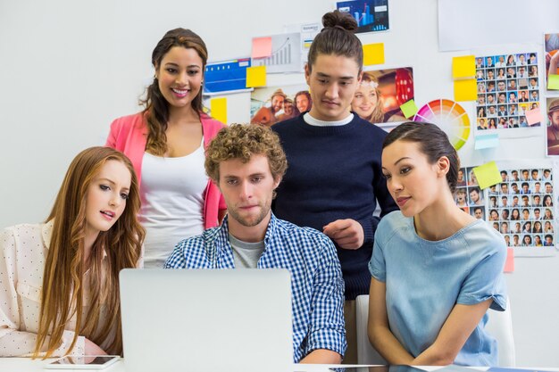 Leidinggevenden die over laptop in bureau bespreken