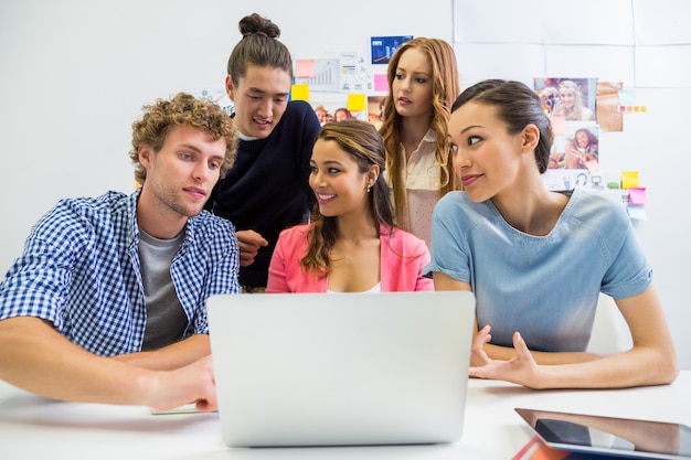 Leidinggevenden die over laptop in bureau bespreken