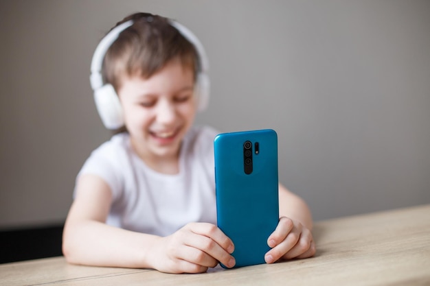 Leisure children technology and people concept  smiling boy with smartphone and headphones