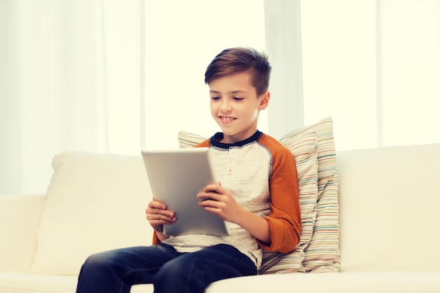 leisure, children, technology and people concept - smiling boy with tablet pc computer at home