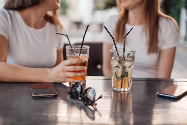 Leisure, holidays, eating, people and food concept - happy friends having dinner at summer garden party and clinking drinks