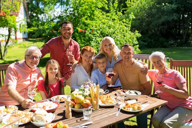 Photo leisure, holidays and people concept - happy family having festive dinner or summer garden party and celebrating