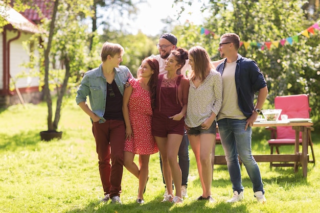 leisure, holidays, reunion, people and friendship concept - happy teenage friends hugging at summer garden party