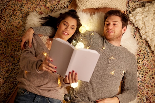 Фото hygge и люди концепция счастливой пары чтение книги дома