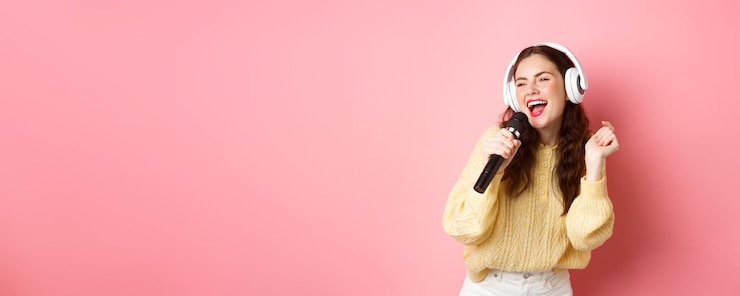 Photo マイクと s を保持しているヘッドフォンでカラオケを楽しんでいるレジャーとライフ スタイルの幸せなブルネットの少女