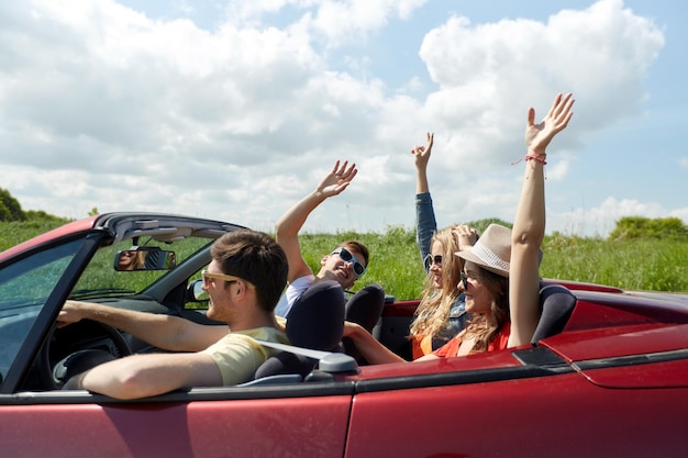 레저, 도로 여행, 여행, 그리고 사람들의 개념 - 시골에서 카브리올레 차를 타고 즐거운 시간을 보내는 행복한 친구들