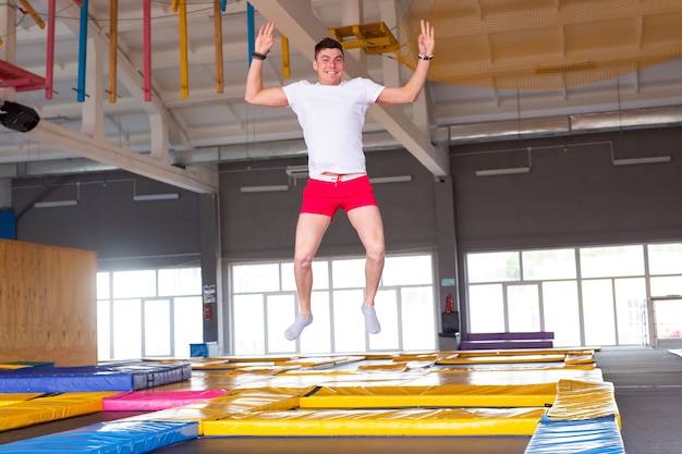 레저, 스포츠 게임 및 관심사-비행 공원에서 trampolining 재미 젊은 남자.