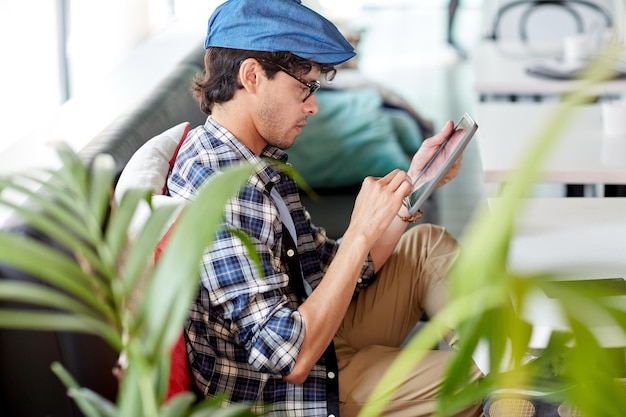 leisure, technology, communication and people concept - creative man with tablet pc computer sitting at cafe table