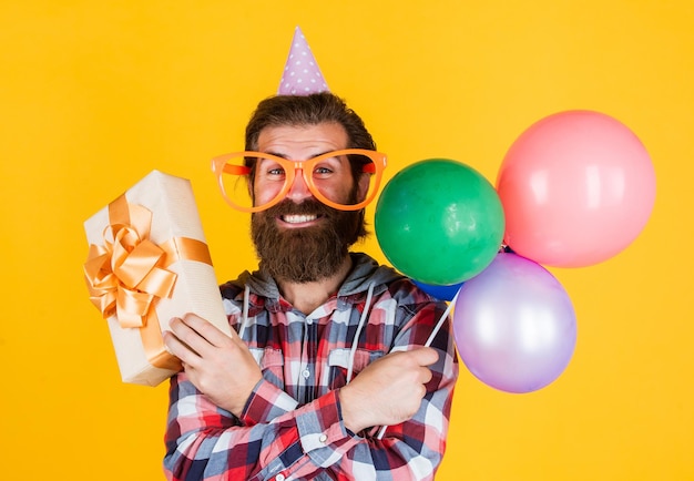 Leisure time feel the happiness happy man with beard man in party glasses hold balloons holiday celebration happy birthday to you corporate party celebrate hello summer summer shopping sales