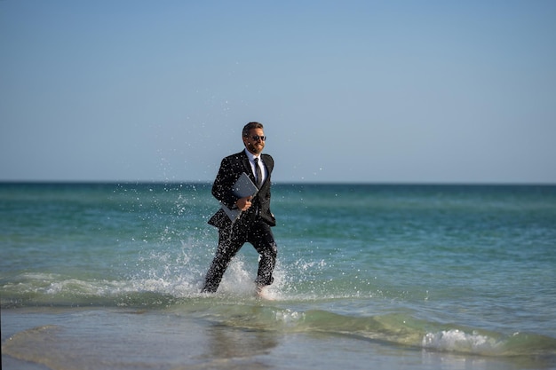 休暇の週末とリモートフリーランスの仕事 狂ったコミック ビジネスマン スーツを着て 海で休む ビーチ 面白いブー