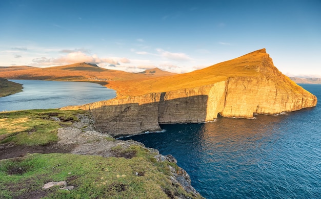 Leitisvatn-meer en de atlantische oceaan bij zonsondergang. vagar-eiland, faeröer. denemarken