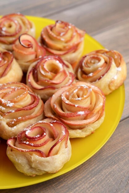 Foto lekker bladerdeeg met appelvormige rozen op plaat op tafel close-up