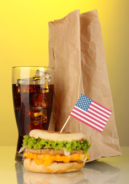 Foto lekker broodje met amerikaanse vlag cola en pakket op gele achtergrond